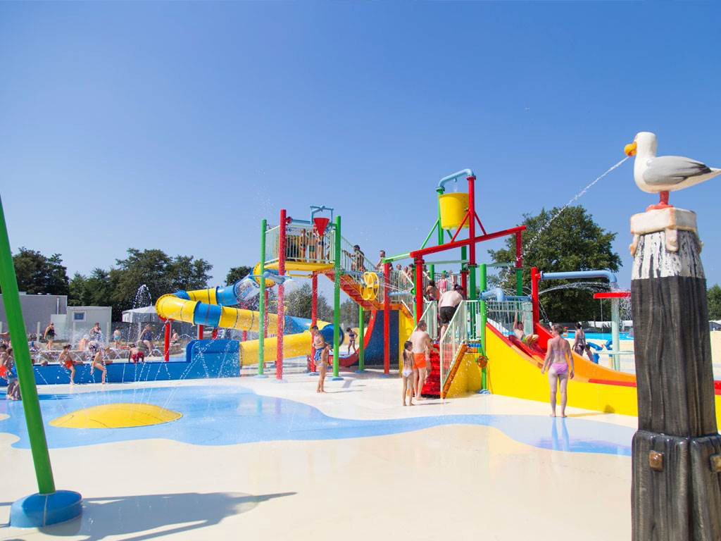 Ein gemütlicher Familiencampingplatz an der Küste, umgeben von Wäldern und Dünen.